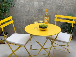 a yellow table with two chairs and a bottle and glasses at AP310 - Colon Bajo in Nerja