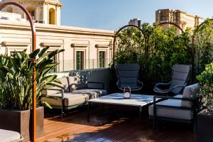 a patio with chairs and a coffee table on a balcony at Rosselli AX Privilege in Valletta