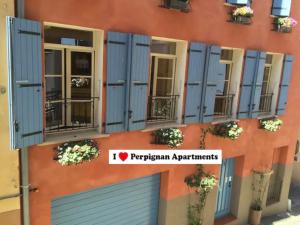 un edificio con persiane blu sul lato di I Love Perpignan Apartments 8 a Perpignano
