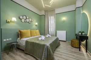 ein grünes Schlafzimmer mit einem Bett und einem Schreibtisch in der Unterkunft Urban Tales in Athen