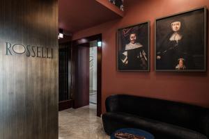 a lobby with a couch and portraits on the wall at Rosselli AX Privilege in Valletta