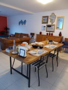 sala de estar con mesa de madera y sillas en La Maison Lydia, en Moissac