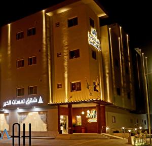 a building with a sign on the front of it at night at شقق لمسات الخير الخيالة للشقق المخدومةAh in Riyadh