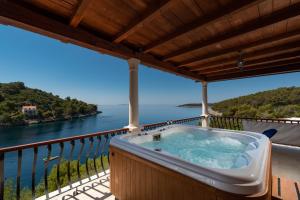 a hot tub on a balcony overlooking the water at Villa Amfora in Prizba