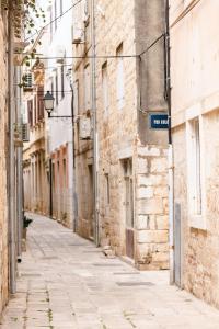 an alley in an old town with a street sign at Pomalo Inn in Vis