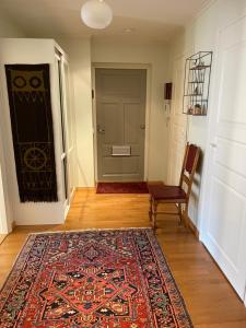 a hallway with a rug and a door with a chair at Kotka Pearl (Kotkan Helmi) in Kotka
