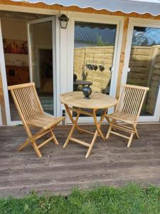 una mesa de madera y 2 sillas en el porche en Spatzennest, 