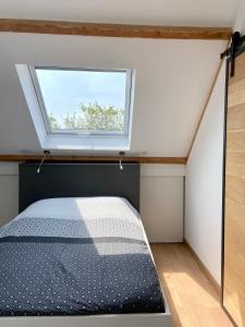 a bedroom with a bed and a window at aux quatre vents in Bénodet