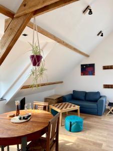 a living room with a table and a blue couch at aux quatre vents in Bénodet