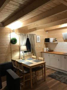 a kitchen with a table and chairs in a room at Leśna Osada -Dominikowo -sauna , balia in Dominikowo