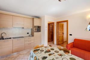 kuchnia i jadalnia ze stołem i kanapą w obiekcie Appartamento Valleverde w Livigno
