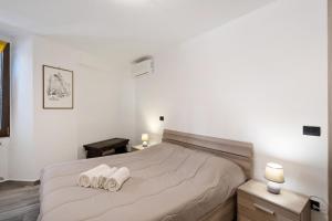Appartamento Mameli في بافينو: غرفة نوم عليها سرير وفوط