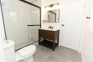 een badkamer met een wastafel, een toilet en een spiegel bij Park & Mill in Bloomfield