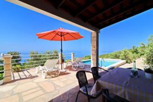 a patio with a table and an umbrella and a pool at Holiday Home Zule in Žrnovo