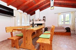 a room with a wooden table and benches and a bed at Holiday Home Zule in Žrnovo