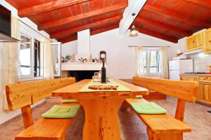 a kitchen with a wooden table and benches at Holiday Home Zule in Žrnovo