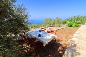 a table with two chairs and the ocean in the background at Holiday Home Zule in Žrnovo