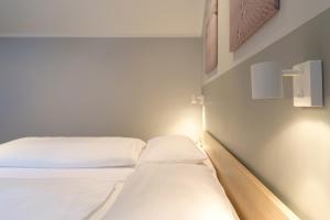two beds in a small room with lights on the wall at Hotel & Restaurant Prüser´s Gasthof in Hellwege