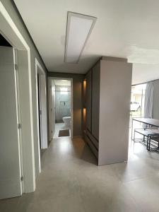 einen Flur mit einem Zimmer mit einem WC und einem Tisch in der Unterkunft Palhoça Casa na Praia de fora Palhoça - 30m do mar in Palhoça