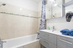 ブシー・サン ・ジョルジュにあるFamily Travel Parisの浴槽、洗面台、鏡のあるバスルーム +23枚の写真