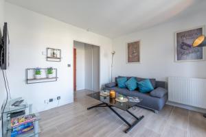 a living room with a couch and a table at Family Travel Paris in Bussy-Saint-Georges