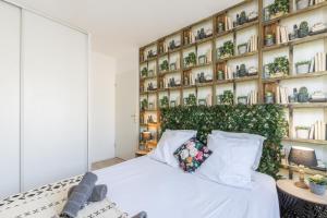 a bedroom with a white bed with a green wall at Family Travel Paris in Bussy-Saint-Georges