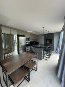 eine Küche mit Holztischen und Stühlen darin in der Unterkunft Palhoça Casa na Praia de fora Palhoça - 30m do mar in Palhoça + 25 Fotos