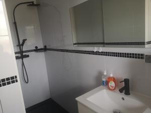 a white bathroom with a sink and a mirror at Haus Am Meer in Mieroszyno