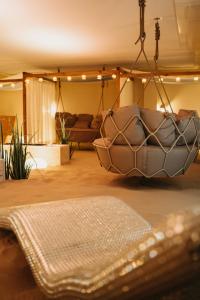 Hotel & Spa Trzy Wyspy في سفينويتشي: غرفة معيشة مع أريكة وكرسي معلق