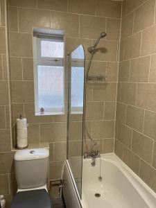 a bathroom with a shower and a toilet and a tub at Impeccable 2-Bed Apartment in Eastbourne in Eastbourne