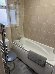 a bathroom with a tub and a toilet and a shower at Impeccable 2-Bed Apartment in Eastbourne in Eastbourne