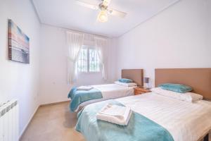 una camera con 2 letti e un ventilatore a soffitto di Garden Apartment with Hot Tub - ER2104LT a Torre-Pacheco