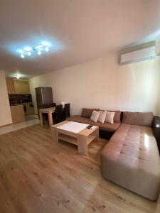 a living room with a couch and a table at Апартамент SUMI in Varna City