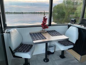 una mesa y sillas en un barco con vistas al agua en Havre du lac à la tortue, en Grand-Mère