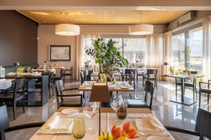 Conca Bella Boutique Hotel & Wine Experience في Vacallo: مطعم بطاولات وكراسي ونوافذ