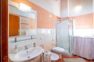 une salle de bain avec un lavabo, des toilettes et une douche dans l'établissement Corte Roveggia - Bilocale Monet, à Vérone