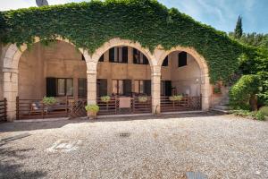 un bâtiment recouvert de lierre avec une clôture et une cour dans l'établissement Corte Roveggia - Bilocale Monet, à Vérone