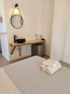 a room with a bed with two towels and a mirror at Mar Adentro in Patitiri