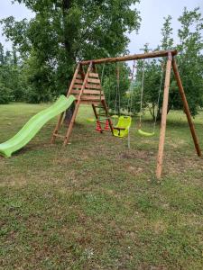 un parco giochi con scivolo verde e altalene di AUBERGE LE GABACHOU a Montpezat-de-Quercy