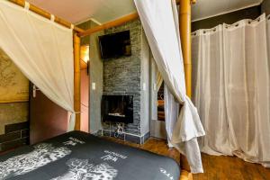 a bedroom with a fireplace and a bed with curtains at Havre de paix Avignon avec Jacuzzi & Sauna in Avignon