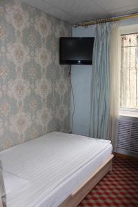 a bedroom with a white bed with a wall at City Hostel & Tours in Ulaanbaatar