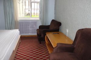 a hotel room with a bed and a desk and chairs at City Hostel & Tours in Ulaanbaatar