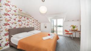 1 dormitorio con 1 cama con manta naranja en Apartments Angela, en Baška Voda