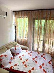 a bedroom with a bed with a white blanket with flowers at Апартамент Silver Star in Sozopol +17 photos