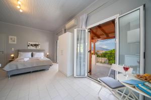 a bedroom with a bed and a sliding glass door at Mary's Studios & Apartment in Sami