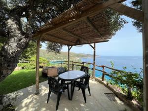 einen Tisch und Stühle auf einer Terrasse mit Meerblick in der Unterkunft Case Vacanza Mare Nostrum in Torre delle Stelle