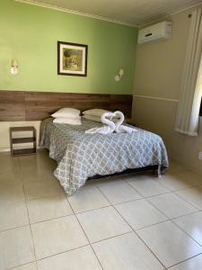 ein Schlafzimmer mit einem Bett mit Handtüchern darauf in der Unterkunft Pousada Montanhas do Sol in São Lourenço