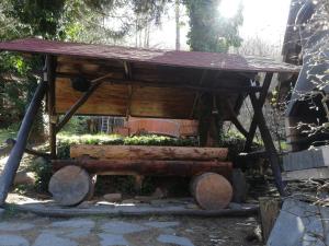 a wooden picnic table with a bench under it at Cabana Farmec Ciubăr - Dézsabáj Kulcsosház in Sovata