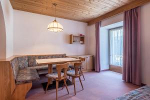uma sala de jantar com uma mesa e cadeiras e um sofá em Ferienparadies Sabina Santner em Alpe di Siusi
