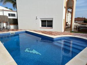 a large blue swimming pool in front of a house at Villa Arcos in Segur de Calafell